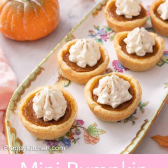 Pinterest graphic of a platter of mini pumpkin pies with whipped cream on top.