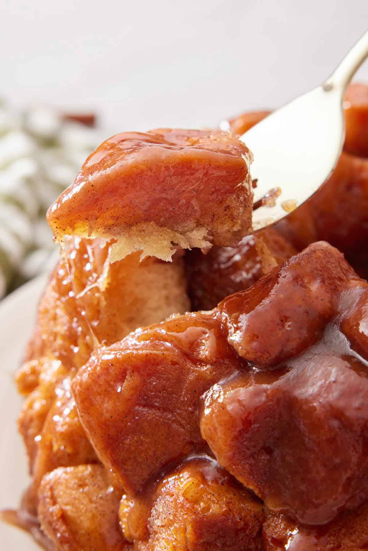 A fork lifting up a piece of monkey bread.