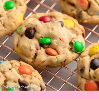 Pinterest graphic of multiple monster cookies cooling on a wire rack.