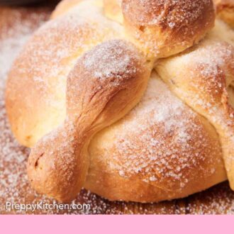 Pinterest graphic of a close up view of Pan de Muerto topped with a sprinkling of sugar.