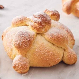 A loaf of Pan de Muerto with star anise scattered around.