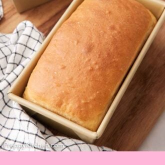 Pinterest graphic of a loaf of potato bread in its baking tin on a wooden board.