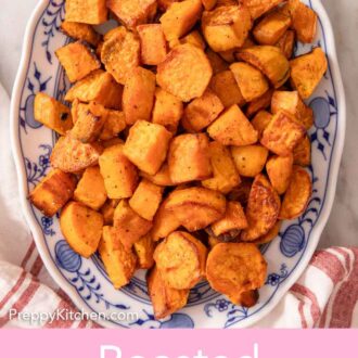 Pinterest graphic of an overhead view of an oval platter of roasted sweet potatoes. Leaves and a linen surrounding it.