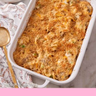 Pinterest graphic of a white baking dish with turkey casserole with a serving spoon, napkin, and plate to the side.
