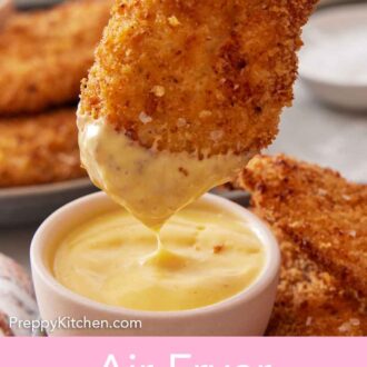 Pinterest graphic of a piece of air fryer chicken tender dipped into mustard.