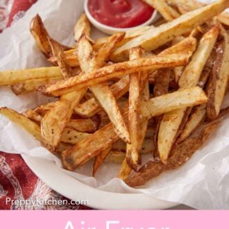 Pinterest graphic of a platter lined with parchment topped with air fryer french fries with ketchup on the side.