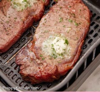 Pinterest graphic of air fryer steak topped with melted herb butter in an air fryer basket.