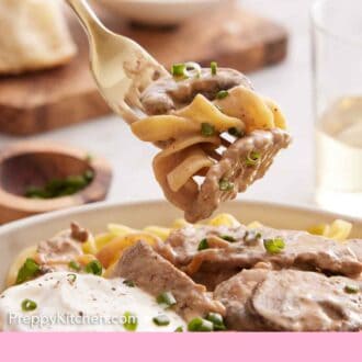 Pinterest graphic of a forkful of beef stroganoff lifted from a bowl.