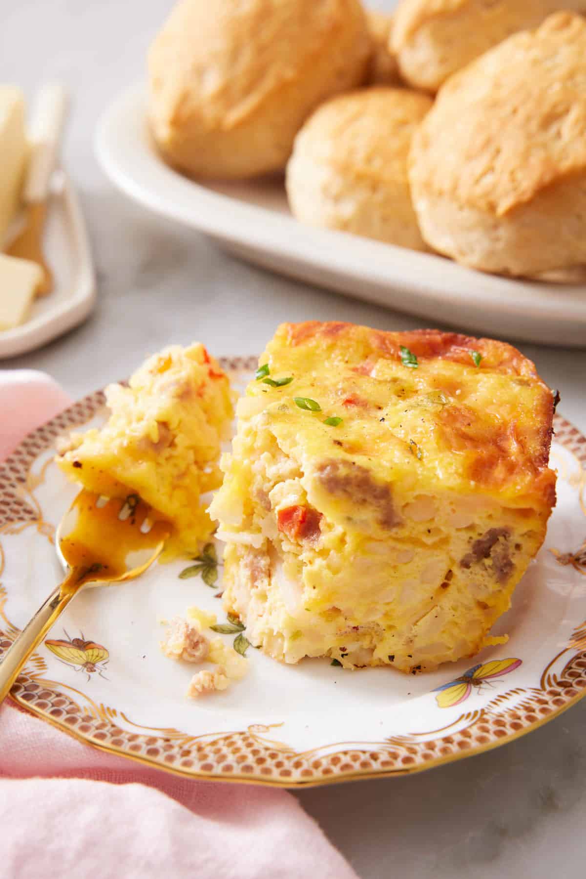 A plate with a piece of breakfast casserole with a bite on a fork.