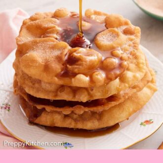 Pinterest graphic of a plate with a stack of bunuelos with piloncillo syrup poured on top.