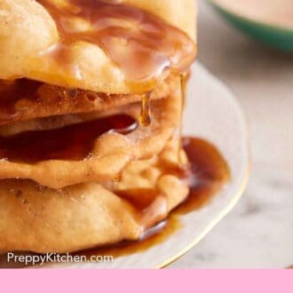 Pinterest graphic of a close up view of bunuelos with piloncillo syrup dripping off it.