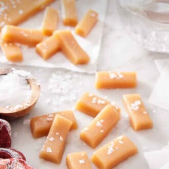 Pinterest graphic of multiple pieces of caramels with additional in the background, topped with sea salt.