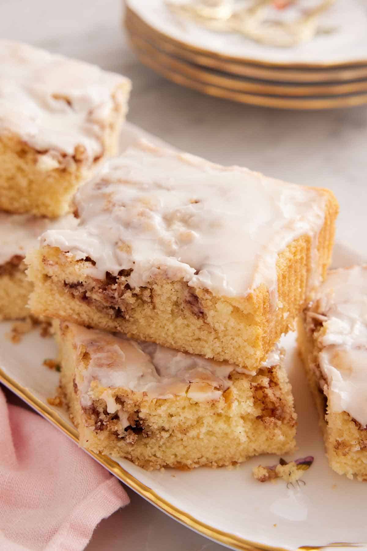 A close up view of a stack of two slices cinnamon roll cake on a platter.