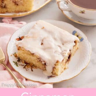 Pinterest graphic of a plate with a slice of cinnamon roll cake with a mug of coffee and more sliced cake in the back.