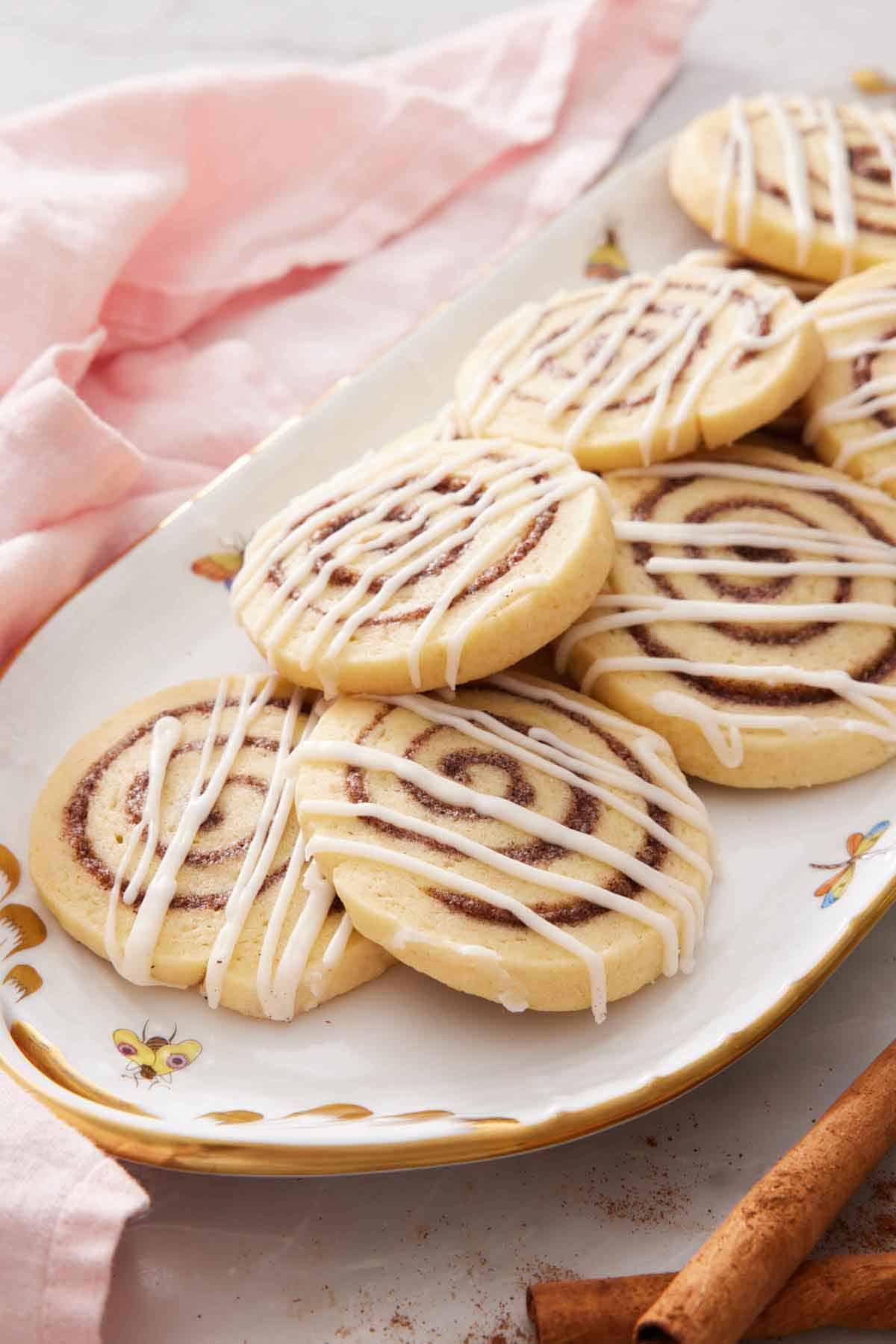 A platter of cinnamon roll cookies with icing drizzled on top.