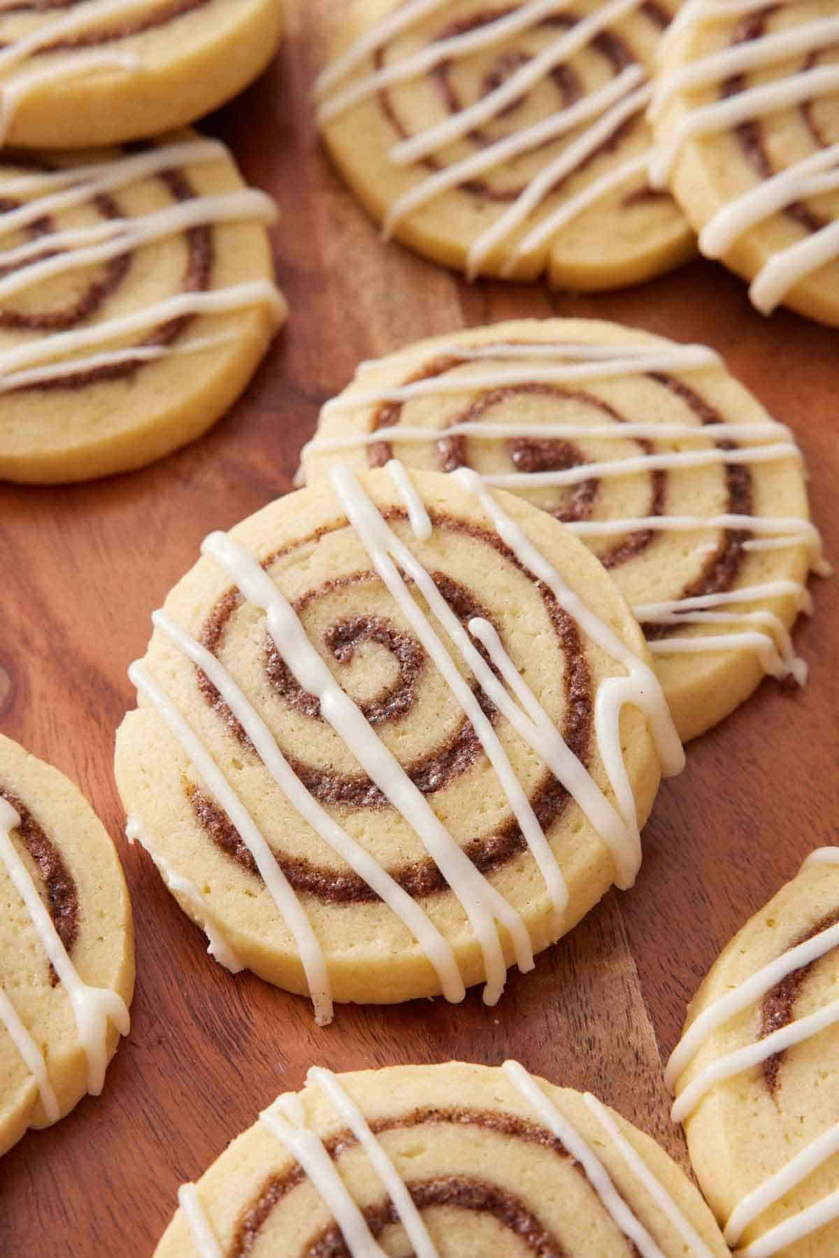 Multiple cinnamon roll cookies all drizzled with icing.