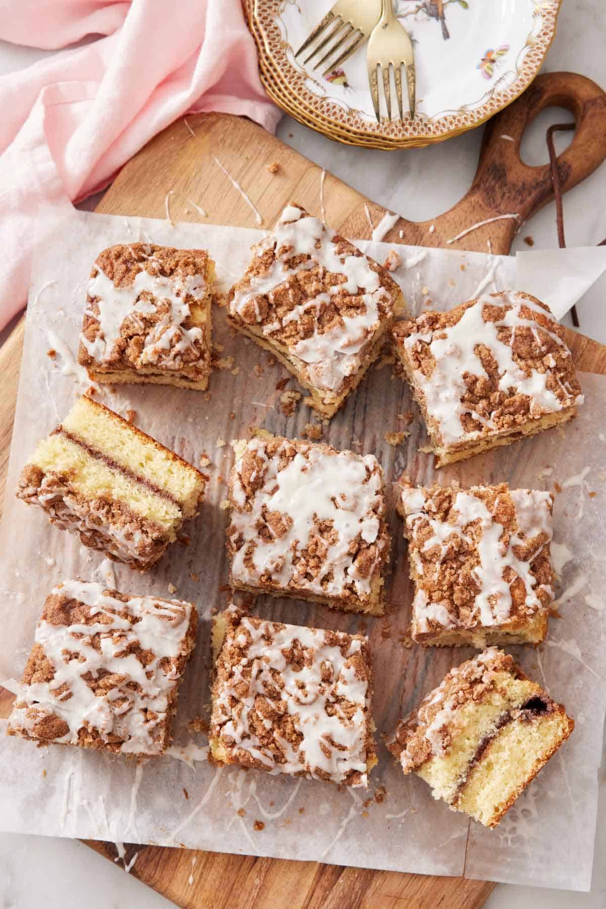 Overhead view of a serving board with nine pieces of coffee cake topped with a glaze.