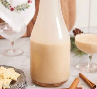Pinterest graphic of a bottle of eggnog with a full glass off to the side and empty glass in the back.