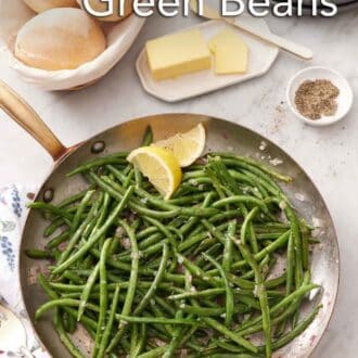 Pinterest graphic of a skillet of French green beans with a side of dinner rolls, butter, and a bowl of pepper.