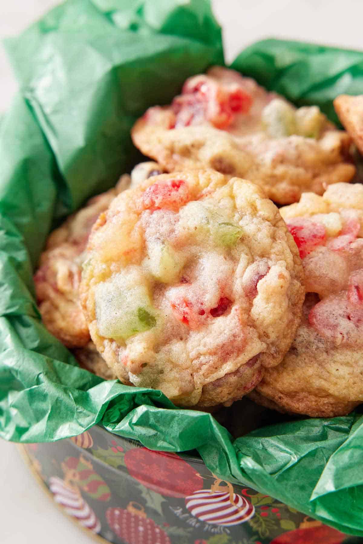 A tin with tissue paper filled with fruitcake cookies.