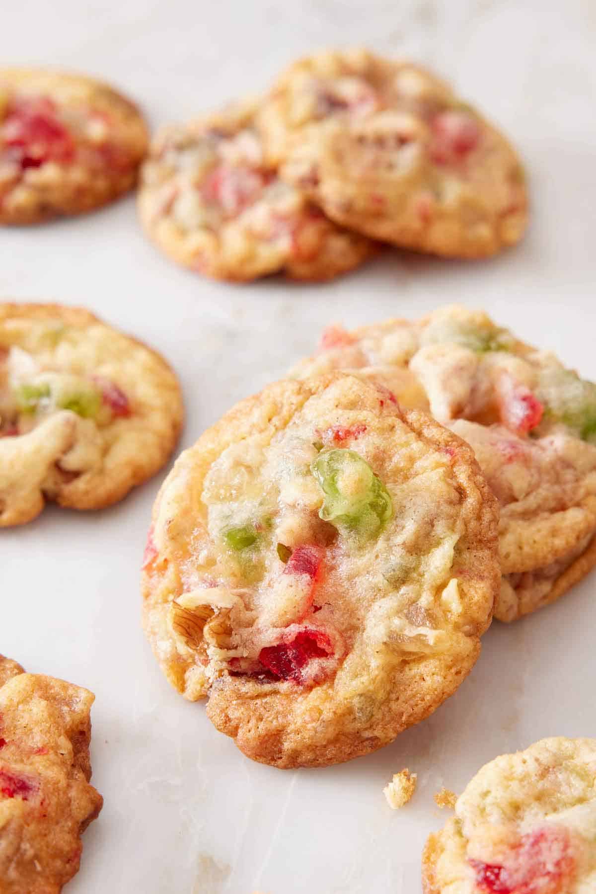 Multiple fruitcake cookies on a marble surface.