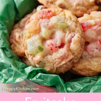 Pinterest graphic of a cookie tin with tissue paper filled with fruitcake cookies.