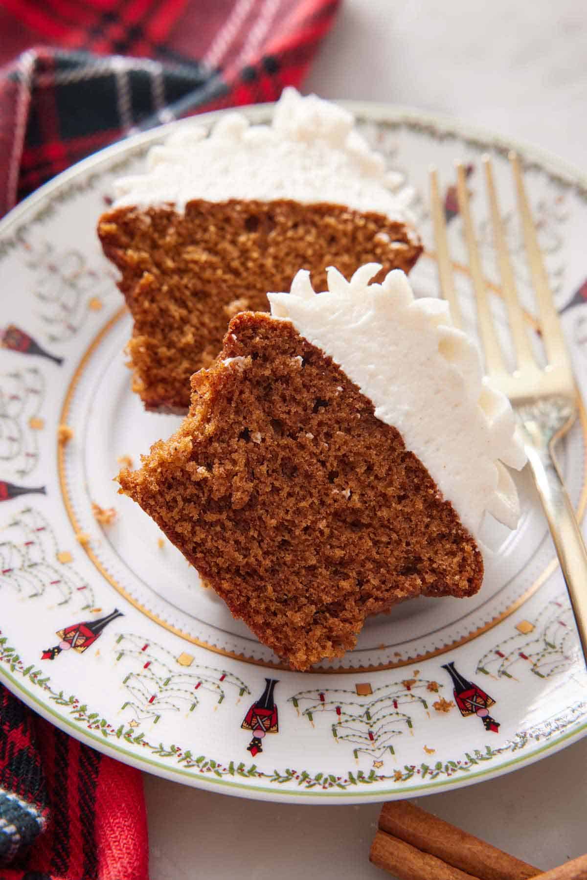 A plate with a gingerbread cupcake cut in half with a fork beside it.