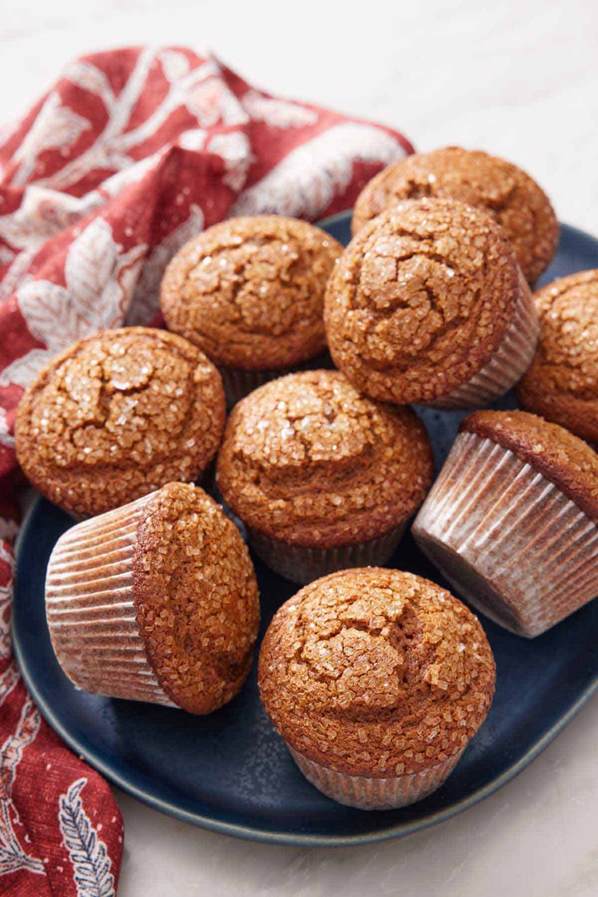 A platter of gingerbread muffins with a linen napkin beside it.