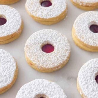 A marble surface with multiple linzer cookies.