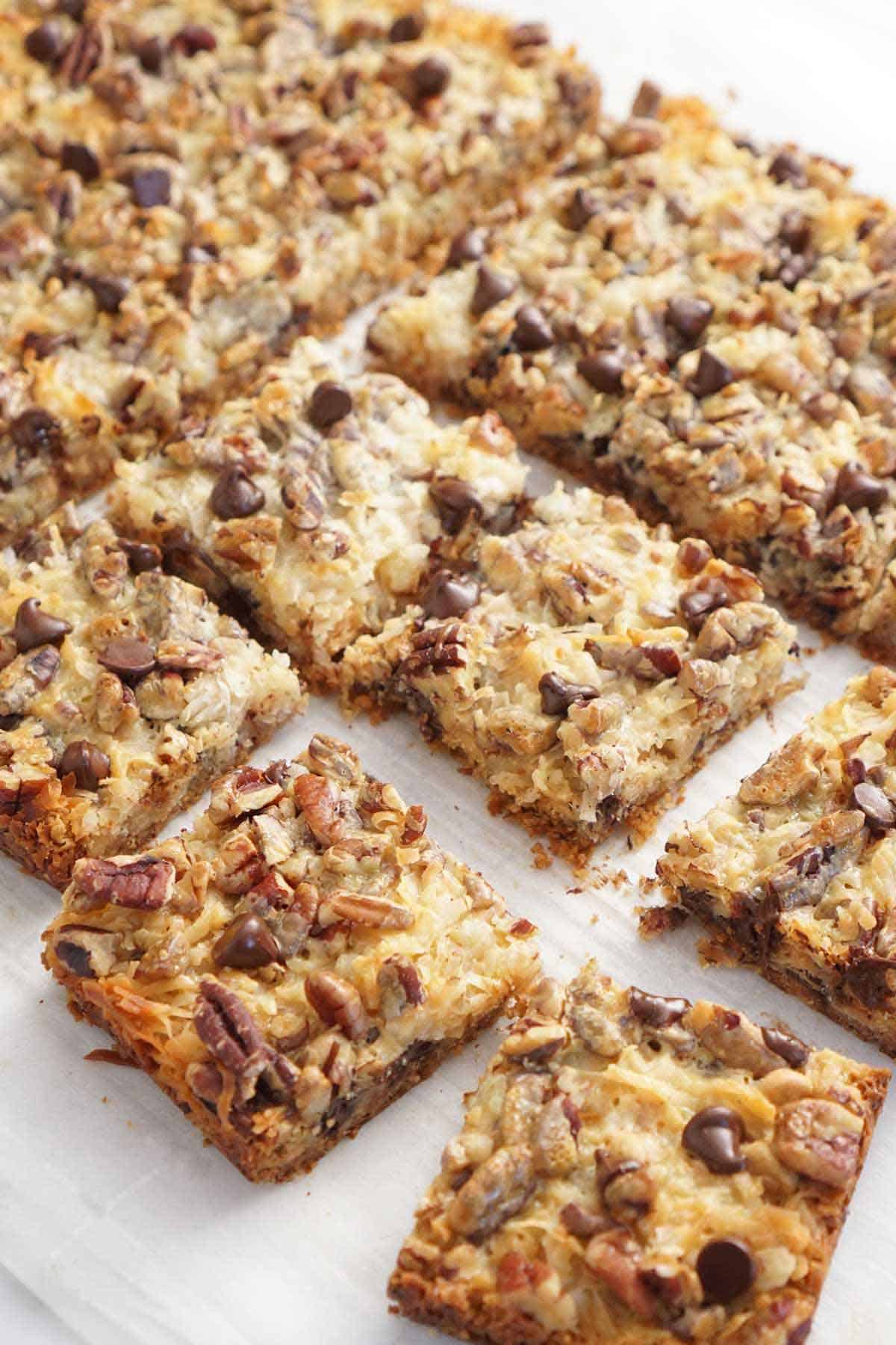 Cut magic cookie bars on a white surface.