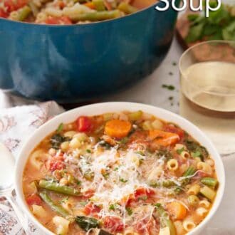 Pinterest graphic of a bowl of minestrone soup with a glass of wine and pot of soup in the background.