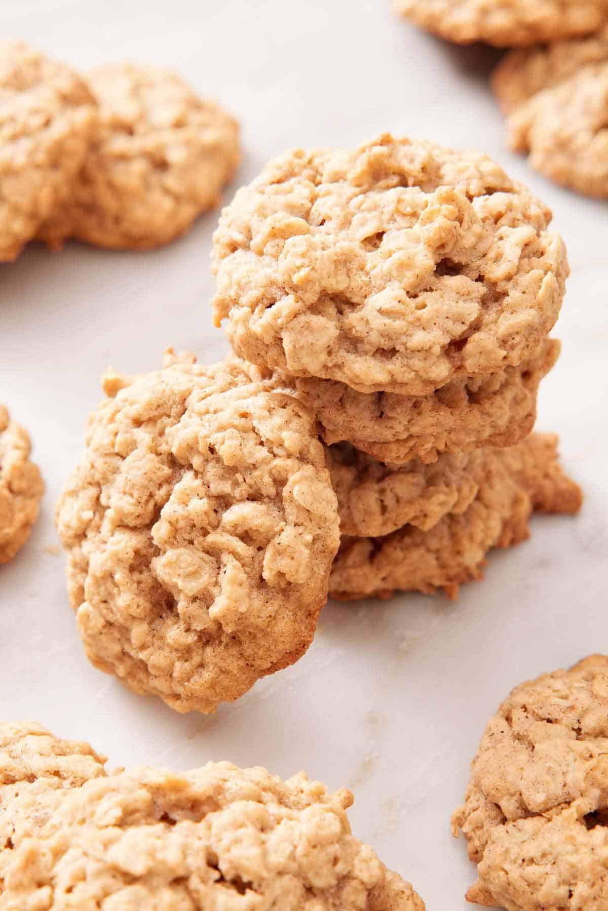 A stack of oatmeal cookies with one leaning beside it.