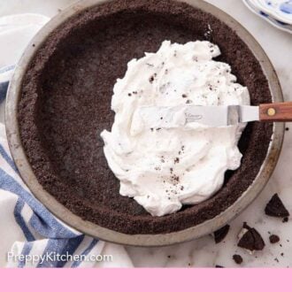 Pinterest graphic of an Oreo pie crust in a pie pan with a topping spread into the crust.