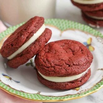 A plate with red velvet cookies with one stacked on top of the other.
