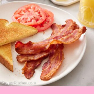 Pinterest graphic of air fryer bacon on a plate with sliced tomatoes and toast.