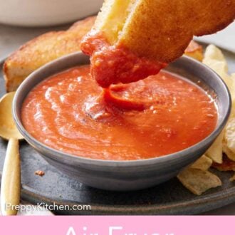 Pinterest graphic of an air fryer grilled cheese dipped into tomato soup.