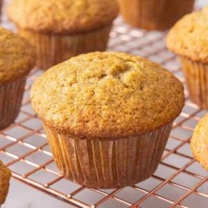 Multiple banana muffins on a cooling rack.