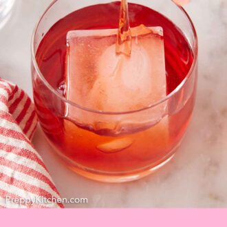 Pinterest graphic of boulevardier strained into a glass with an ice cube.