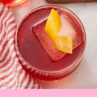 Pinterest graphic of an overhead view of boulevardier in a glass with an orange twist garnish.