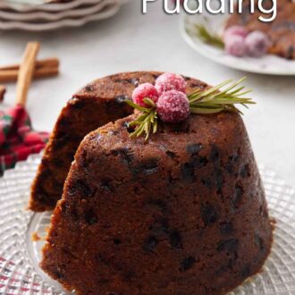 Pinterest graphic of a platter with a Christmas pudding with a slice cut out with sugared cranberries and rosemary on top.