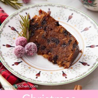 Pinterest graphic of a slice of Christmas pudding with some sugared cranberries and rosemary on the side on a plate.