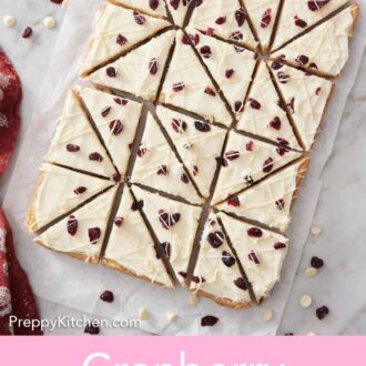 Pinterest graphic of an overhead view of cranberry bliss bars on a parchment paper over a marble counter.