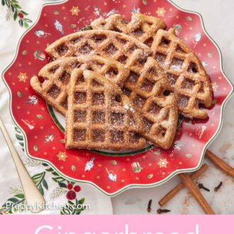 Pinterest graphic of pieces of gingerbread waffles on a festive plate dusted with powdered sugar.