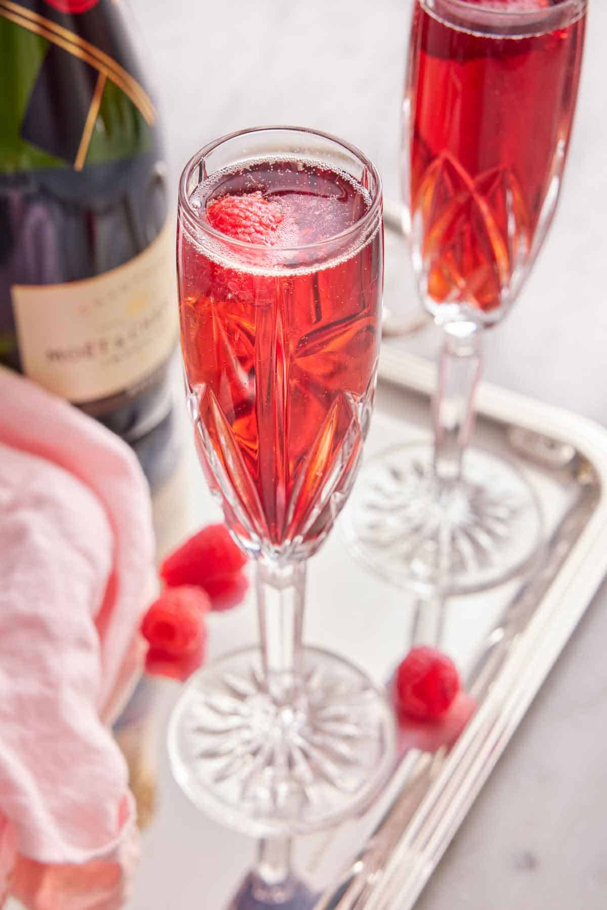 Two glasses of Kir Royale and a bottle of champagne on a tray.