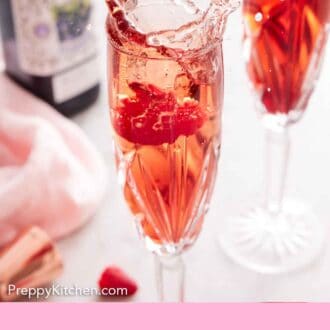 Pinterest graphic of glasses of Kir Royale with a raspberry dropped in one, causing a splash.