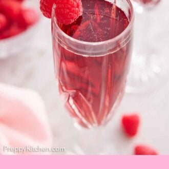Pinterest graphic of a glass of Kir Royale with a raspberry on the rim.