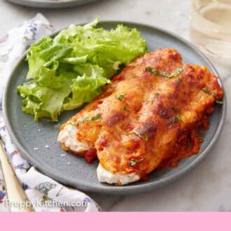Pinterest graphic of a plate with manicotti and salad.