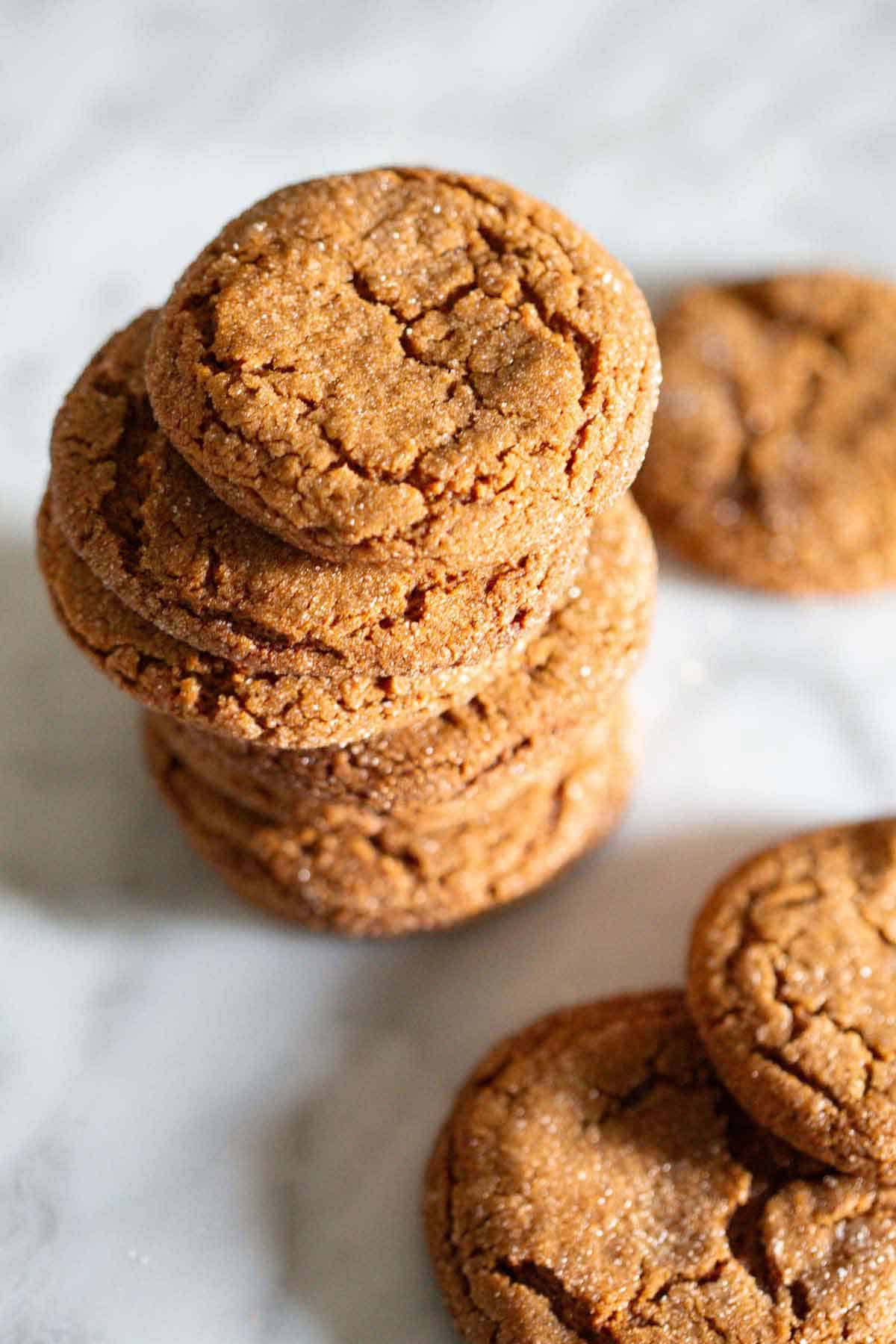 A stack of molasses cookies with more surrounding it.