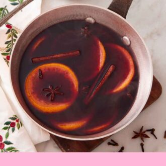 Pinterest graphic of an overhead view of a skillet of mulled wine with a ladle off to the side.