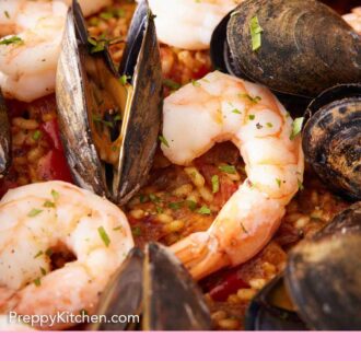 Pinterest graphic of a close up view of paella in a skillet, highlighting the shrimp and mussels.